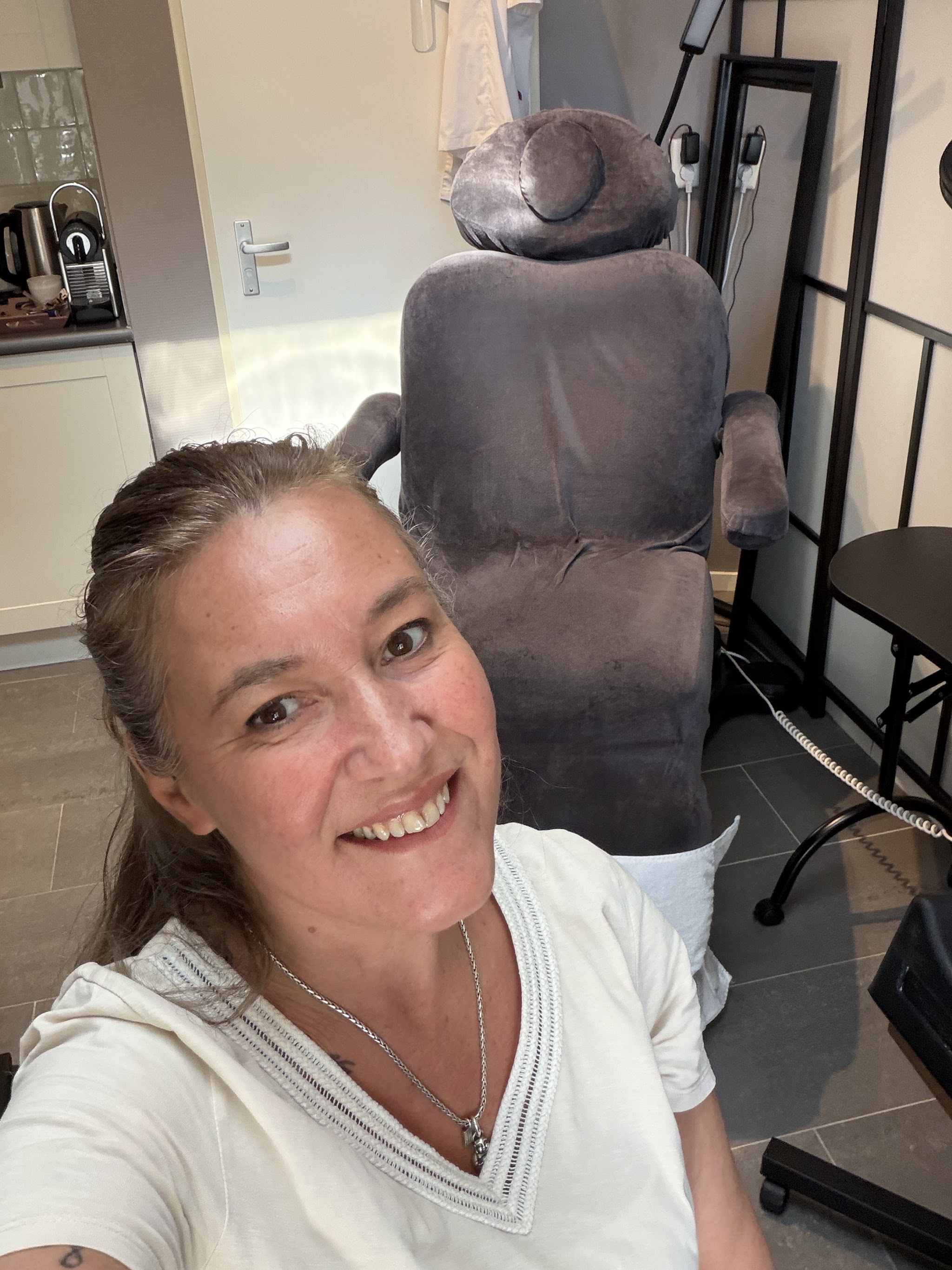 Selfie in de behandelruimte, met de behandelstoel achter haar